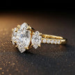 Side view of a marquise cut three-stone lab-grown diamond engagement ring in 18kt yellow gold with diamond shoulders