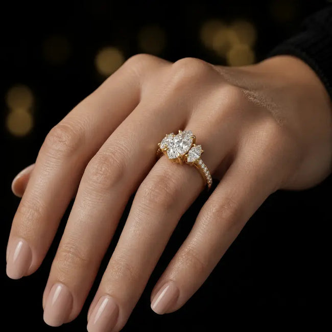 Marquise cut three-stone lab-grown diamond engagement ring in 18kt yellow gold with diamond shoulders worn on hand
