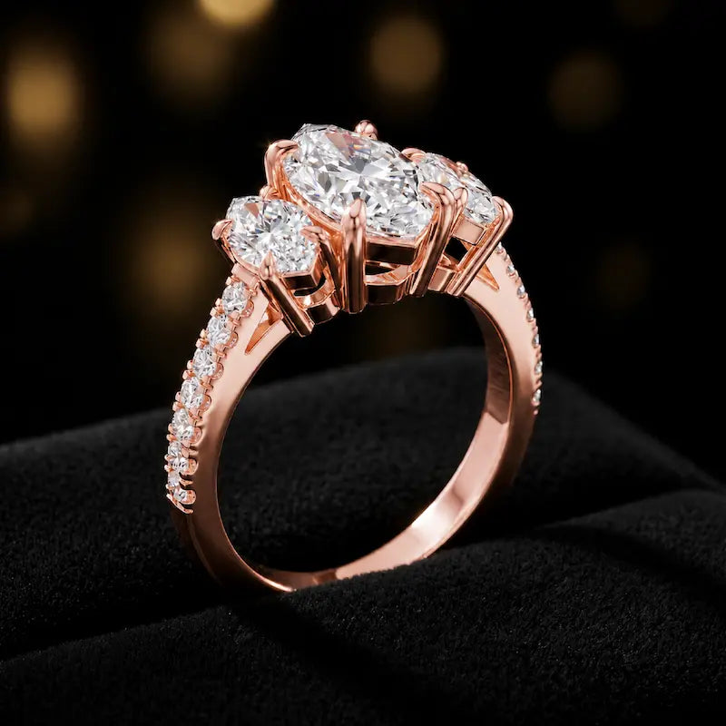 Angled view of a marquise cut three-stone lab-grown diamond engagement ring in 18kt rose gold with diamond shoulders