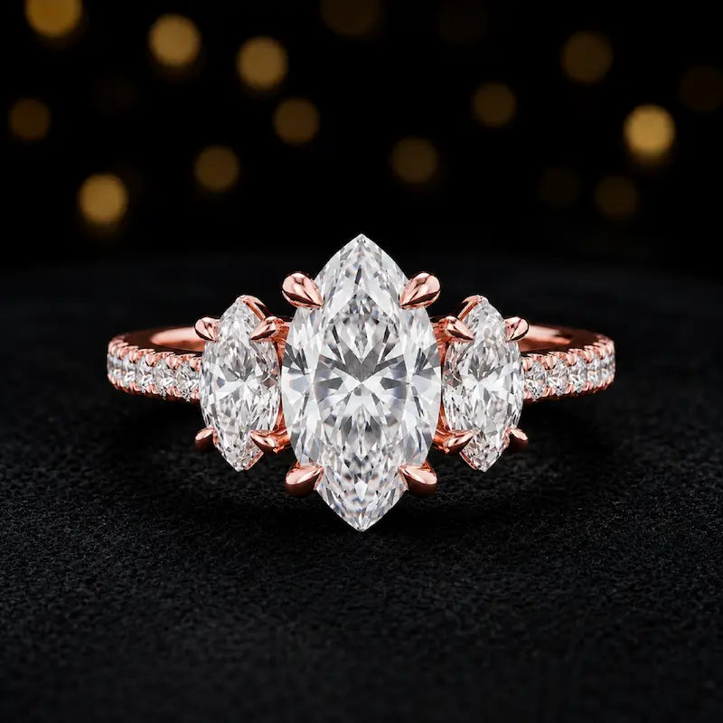 Front view of a marquise cut three-stone lab-grown diamond engagement ring in 18kt rose gold with diamond shoulders