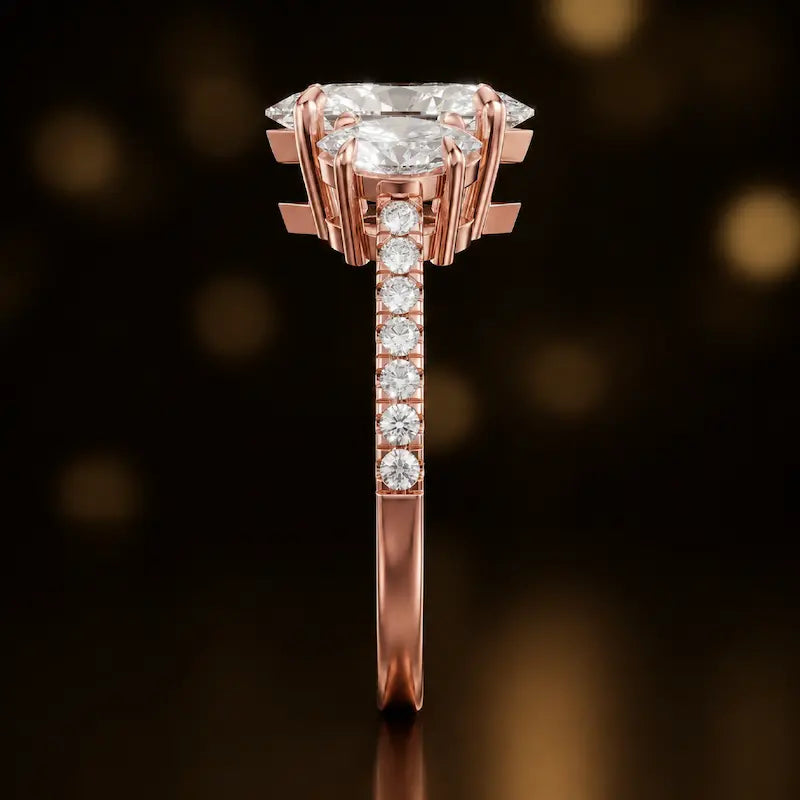 Side profile of a marquise cut three-stone lab-grown diamond engagement ring in 18kt rose gold showing the diamond band