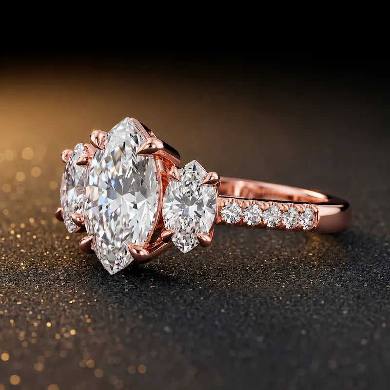 Side view of a marquise cut three-stone lab-grown diamond engagement ring in 18kt rose gold with diamond shoulders