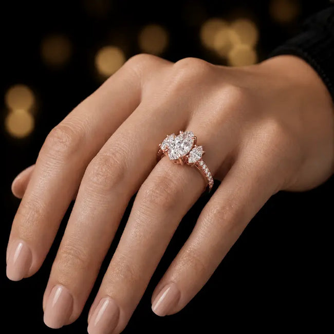Marquise cut three-stone lab-grown diamond engagement ring in 18kt rose gold with diamond shoulders worn on hand