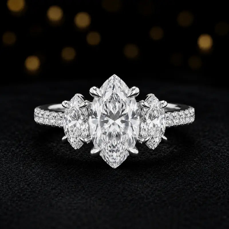 Front view of a marquise cut three-stone lab-grown diamond engagement ring in 18kt white gold with diamond shoulders
