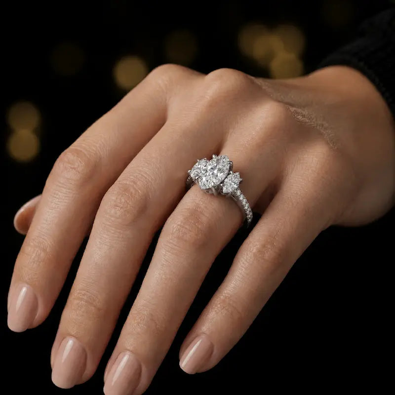 Marquise cut three-stone lab-grown diamond engagement ring in 18kt white gold with diamond shoulders worn on hand
