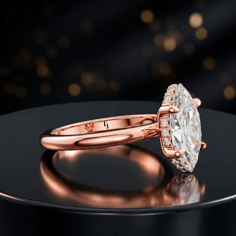 Angled view of 4-claw marquise cut engagement ring with hidden halo in 18kt rose gold