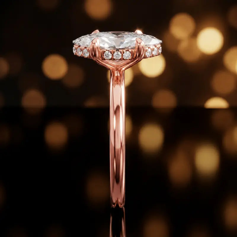 Side profile of 4-claw marquise cut engagement ring with hidden halo in 18kt rose gold