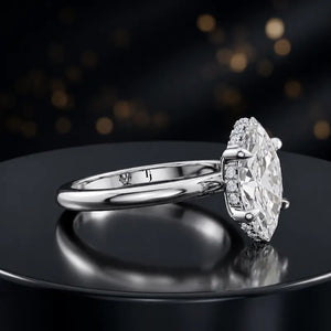Angled view of 4-claw marquise cut engagement ring with hidden halo in 18kt white gold