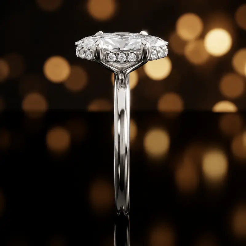 Side profile of 4-claw marquise cut engagement ring with hidden halo in 18kt white gold