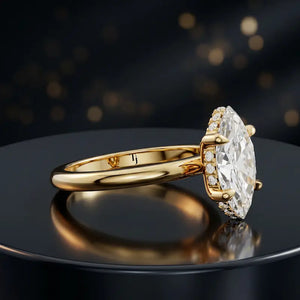 Angled view of 4-claw marquise cut engagement ring with hidden halo in 18kt yellow gold