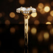 Side profile of 4-claw marquise cut engagement ring with hidden halo in 18kt yellow gold