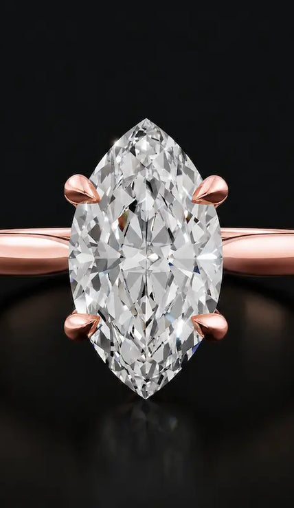 Front view of a 1.5 carat marquise cut diamond solitaire engagement ring in an 18kt rose gold 4 claw setting by TJ Diamond