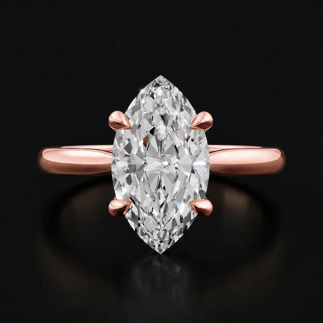 Front view of a 1.5 carat marquise cut diamond solitaire engagement ring in an 18kt rose gold 4 claw setting by TJ Diamond