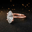 Angled side view of a 1.5 carat marquise cut diamond solitaire engagement ring in an 18kt rose gold 4 claw setting by TJ Diamond
