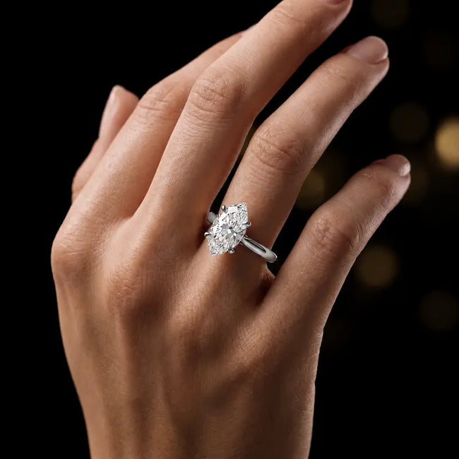 1.5 carat marquise cut diamond solitaire engagement ring in an 18kt white gold 4 claw setting worn on a hand, by TJ Diamond