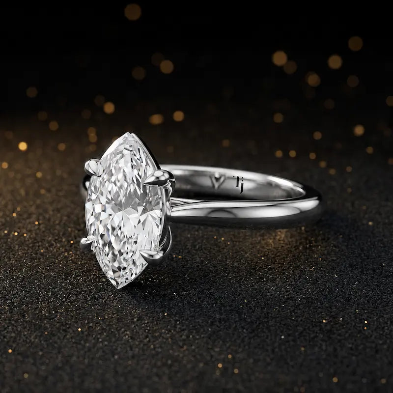 Angled side view of a 1.5 carat marquise cut diamond solitaire engagement ring in an 18kt white gold 4 claw setting by TJ Diamond