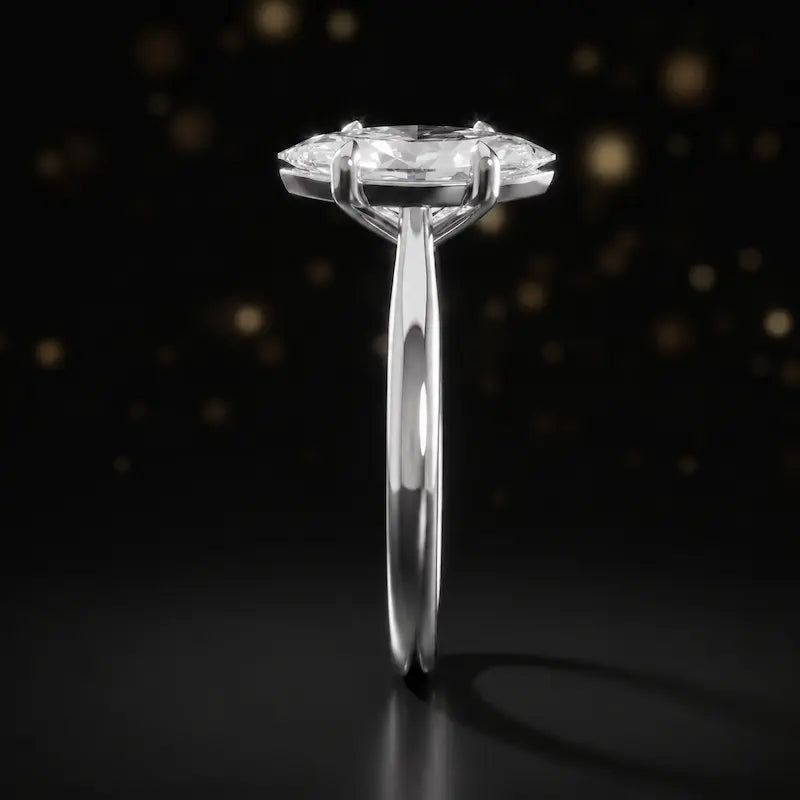 Side profile of a 1.5 carat marquise cut diamond solitaire engagement ring showing the cathedral setting and 18kt white gold band by TJ Diamond