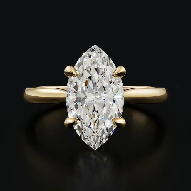 Front view of a 1.5 carat marquise cut diamond solitaire engagement ring in an 18kt yellow gold 4 claw setting by TJ Diamond