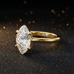 Angled side view of a 1.5 carat marquise cut diamond solitaire engagement ring in an 18kt yellow gold 4 claw setting by TJ Diamond