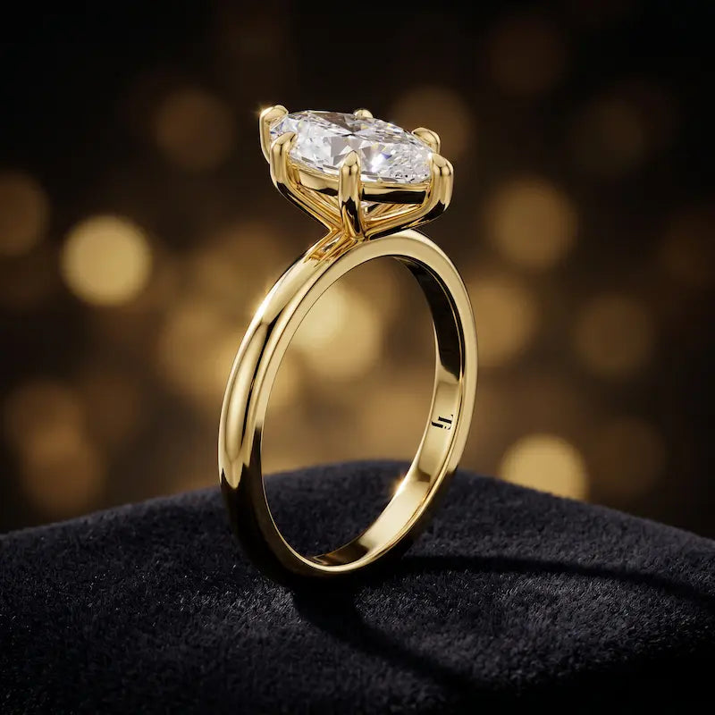 Angled side view of a 1.5 carat marquise cut diamond solitaire engagement ring in an 18kt yellow gold 6 claw setting by TJ Diamond