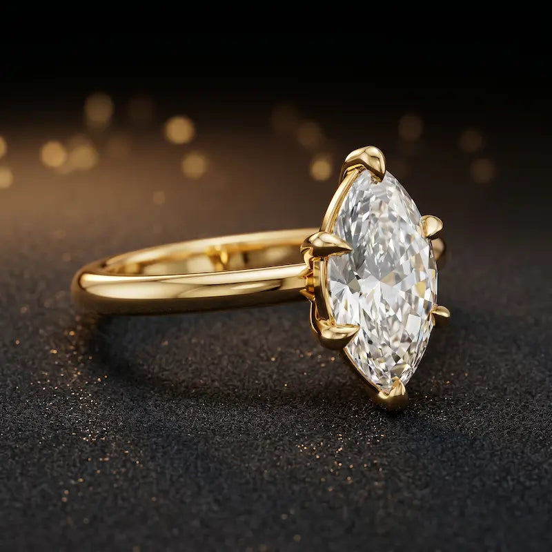 Angled side view of a 1.5 carat marquise cut diamond solitaire engagement ring in an 18kt yellow gold 6 claw setting by TJ Diamond