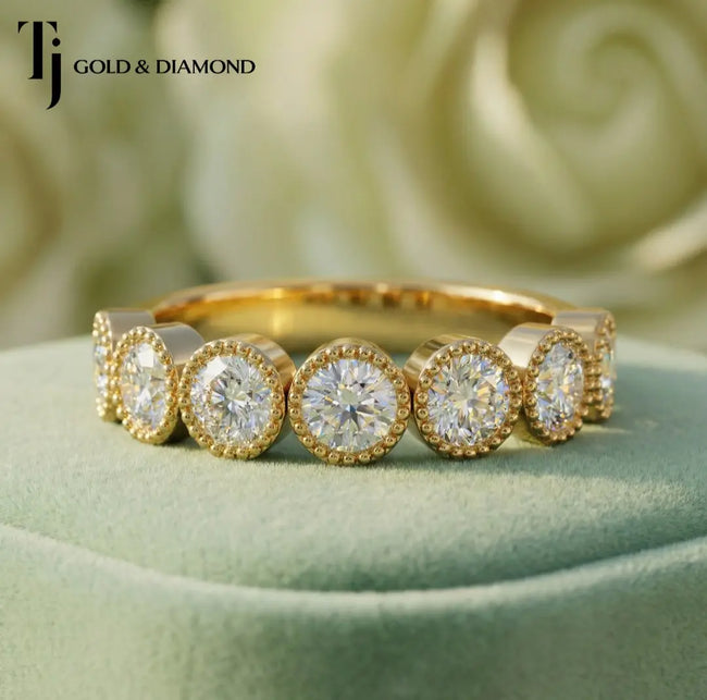 Close-up of Milgrain Bezel Half Eternity diamond wedding band in 18kt yellow gold, round brilliant diamonds framed with milgrain detailing