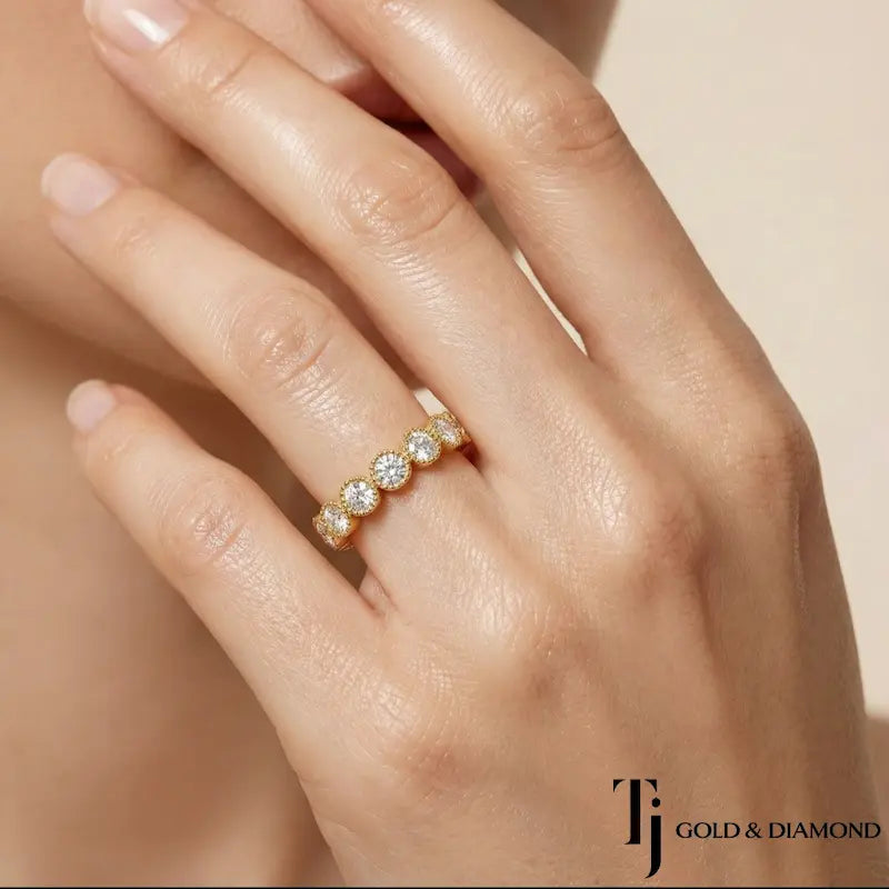 Milgrain bezel setting full eternity diamond wedding band in 18kt yellow gold worn on hand with round brilliant lab-grown diamonds.