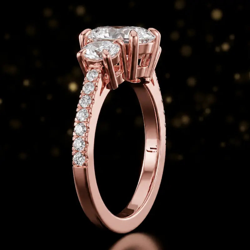 Side profile of an oval cut three-stone lab-grown diamond engagement ring in 18kt rose gold showing the diamond band