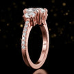 Side profile of an oval cut three-stone lab-grown diamond engagement ring in 18kt rose gold showing the diamond band
