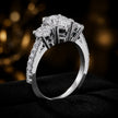 Angled view of an oval cut three-stone lab-grown diamond engagement ring in 18kt white gold with diamond shoulders