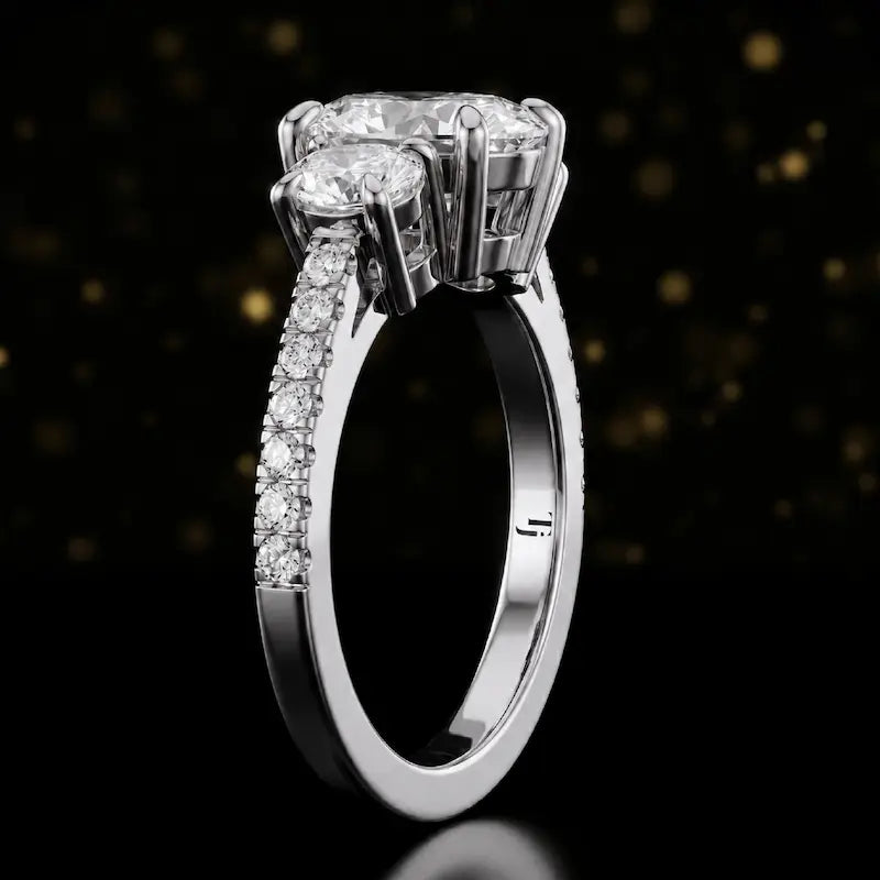 Side profile of an oval cut three-stone lab-grown diamond engagement ring in 18kt white gold showing the diamond band