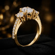 Angled view of an oval cut three-stone lab-grown diamond engagement ring in 18kt yellow gold with diamond shoulders