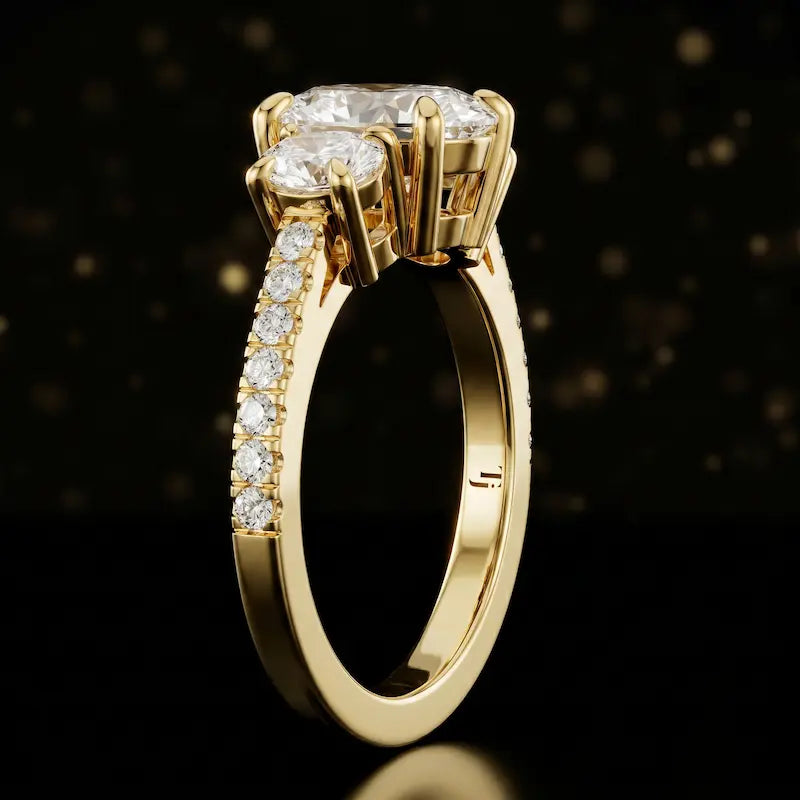 Side profile of an oval cut three-stone lab-grown diamond engagement ring in 18kt yellow gold showing the diamond band