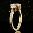 Side profile of an oval cut three-stone lab-grown diamond engagement ring in 18kt yellow gold showing the diamond band