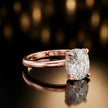 Angled view of 4-claw oval cut engagement ring with hidden halo in 18kt rose gold