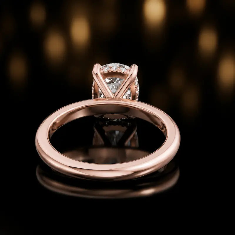 Back view of 4-claw oval cut engagement ring with hidden halo in 18kt rose gold