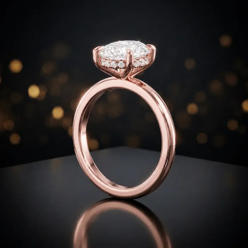 Front view of 4-claw oval cut engagement ring with hidden halo in 18kt rose gold