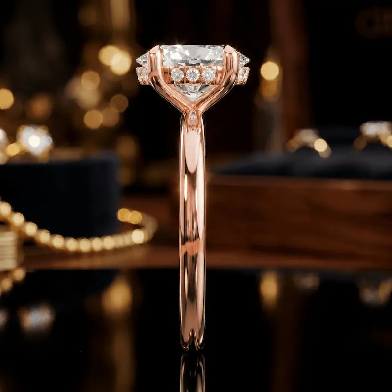 Side profile of 4-claw oval cut engagement ring with hidden halo in 18kt rose gold