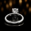 Back view of 4-claw oval cut engagement ring with hidden halo in 18kt white gold