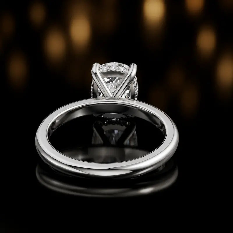Back view of 4-claw oval cut engagement ring with hidden halo in 18kt white gold