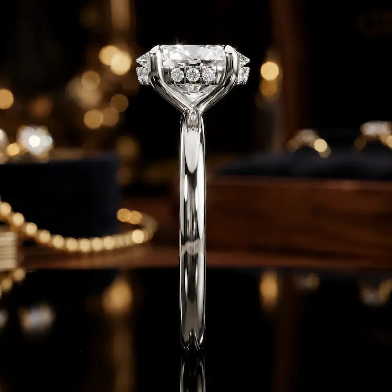 Side profile of 4-claw oval cut engagement ring with hidden halo in 18kt white gold