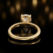 Back view of 4-claw oval cut engagement ring with hidden halo in 18kt yellow gold