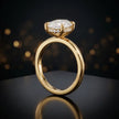 Front view of 4-claw oval cut engagement ring with hidden halo in 18kt yellow gold