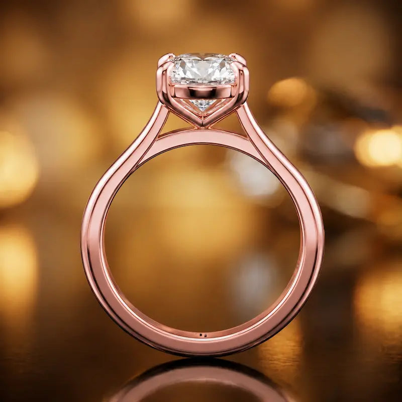 Front-on view of a 1.5 carat oval cut diamond solitaire engagement ring showing the full 18kt rose gold band and 4 claw cathedral setting by TJ Diamond