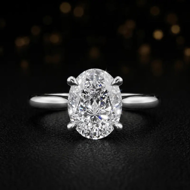 Front view of a 1.5 carat oval cut diamond solitaire engagement ring in an 18kt white gold 4 claw setting by TJ Diamond