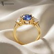Side view of an Oval Cut Lab-Created Blue Sapphire & Lab-Grown Diamond Trilogy Ring in 18kt yellow gold showing the handcrafted trilogy basket setting.