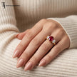 Model wearing an oval cut lab-created ruby trilogy engagement ring in 18kt yellow gold with oval lab-grown diamond side stones.