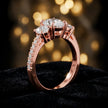 Angled view of a pear cut three-stone lab-grown diamond engagement ring in 18kt rose gold with diamond shoulders