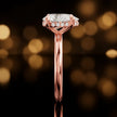 Side profile of 4-claw pear cut engagement ring with hidden halo in 18kt rose gold