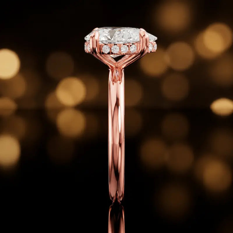 Side profile of 4-claw pear cut engagement ring with hidden halo in 18kt rose gold